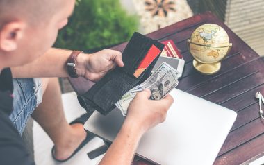 Young man looking down taking money out of his wallet to pay for something